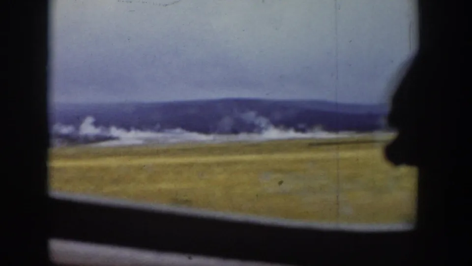 1939 Wyoming 8mm frame of open grassland and low hills seen from a moving vehicle.