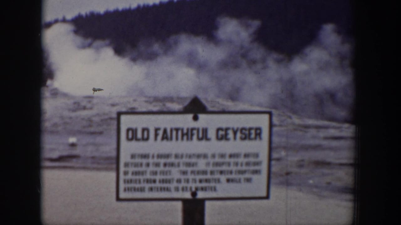 Faded 1939 Wyoming home-movie frame of the Old Faithful sign during a geyser eruption.