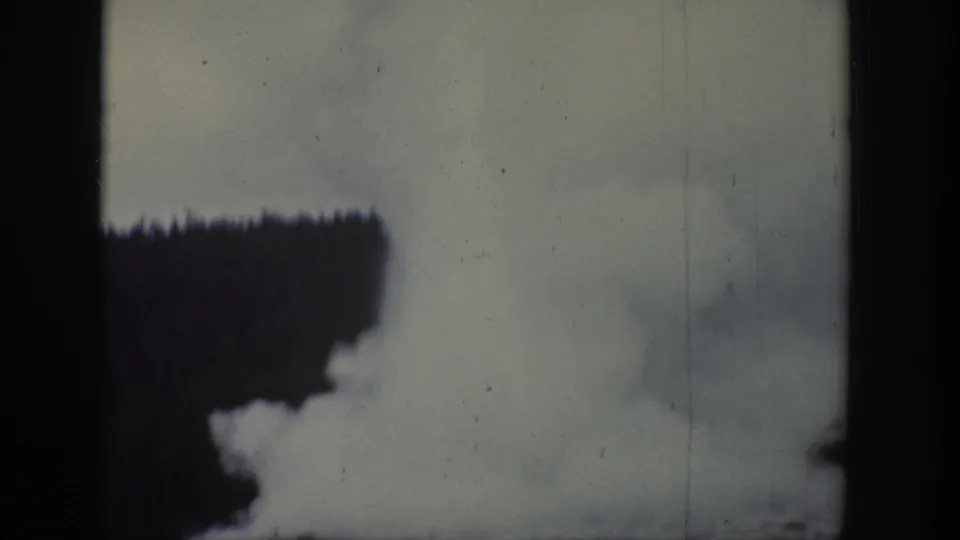 1939 Wyoming home-movie view of dense geothermal steam spreading across the lower frame near forest.