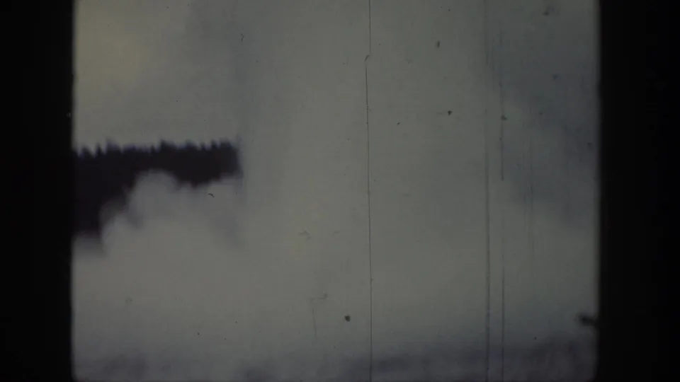 1939 Wyoming 8mm frame with a dark gate edge, pale sky, and a smoke-like plume near the top.