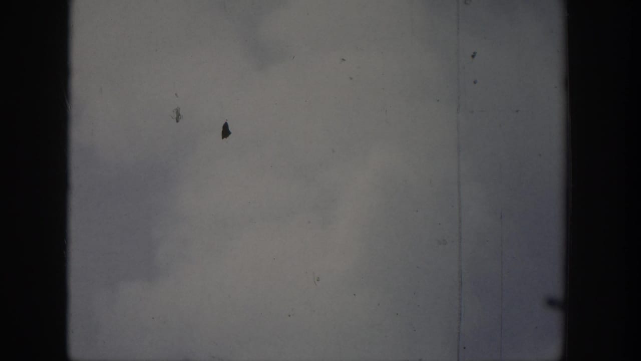 1939 Wyoming 8mm footage showing cloudy sky over water, framed by dark vertical edges and visible film wear.
