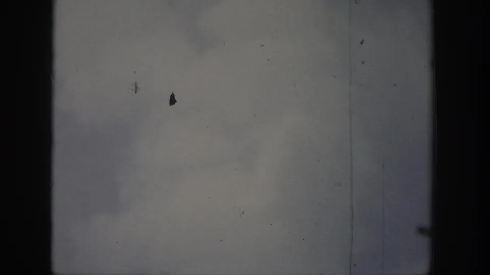 1939 Wyoming 8mm footage showing cloudy sky over water, framed by dark vertical edges and visible film wear.