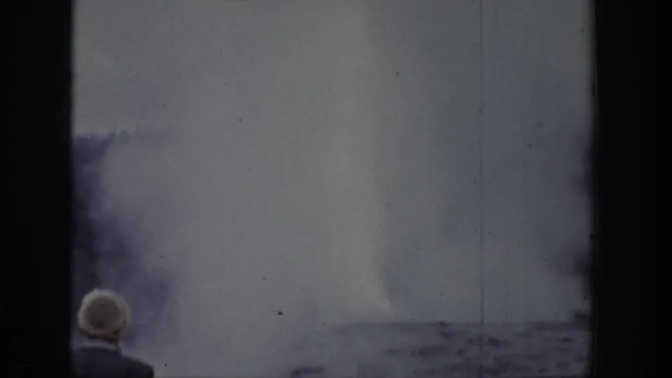 A white-haired person appears at the lower left of a 1939 Wyoming 8mm view of clouds and water.