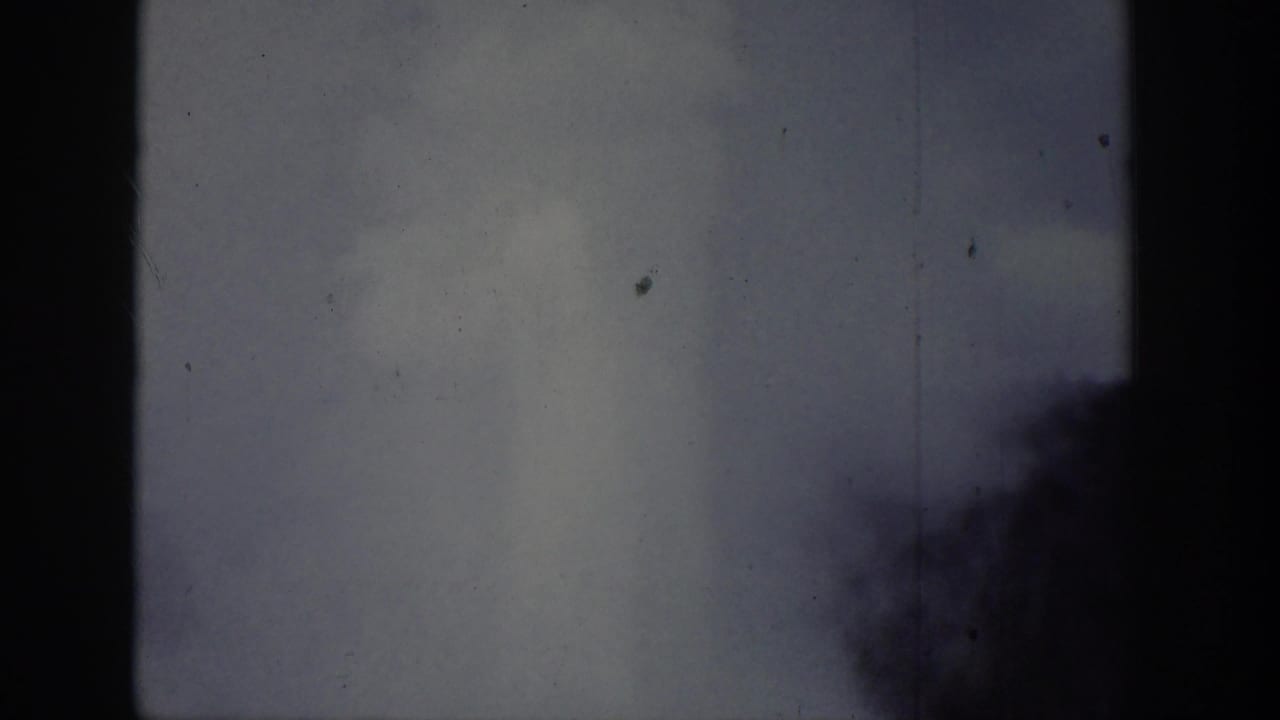 Wyoming-attributed 1939 home-movie frame with a pale plume partly obscured by dark tree or edge silhouettes.