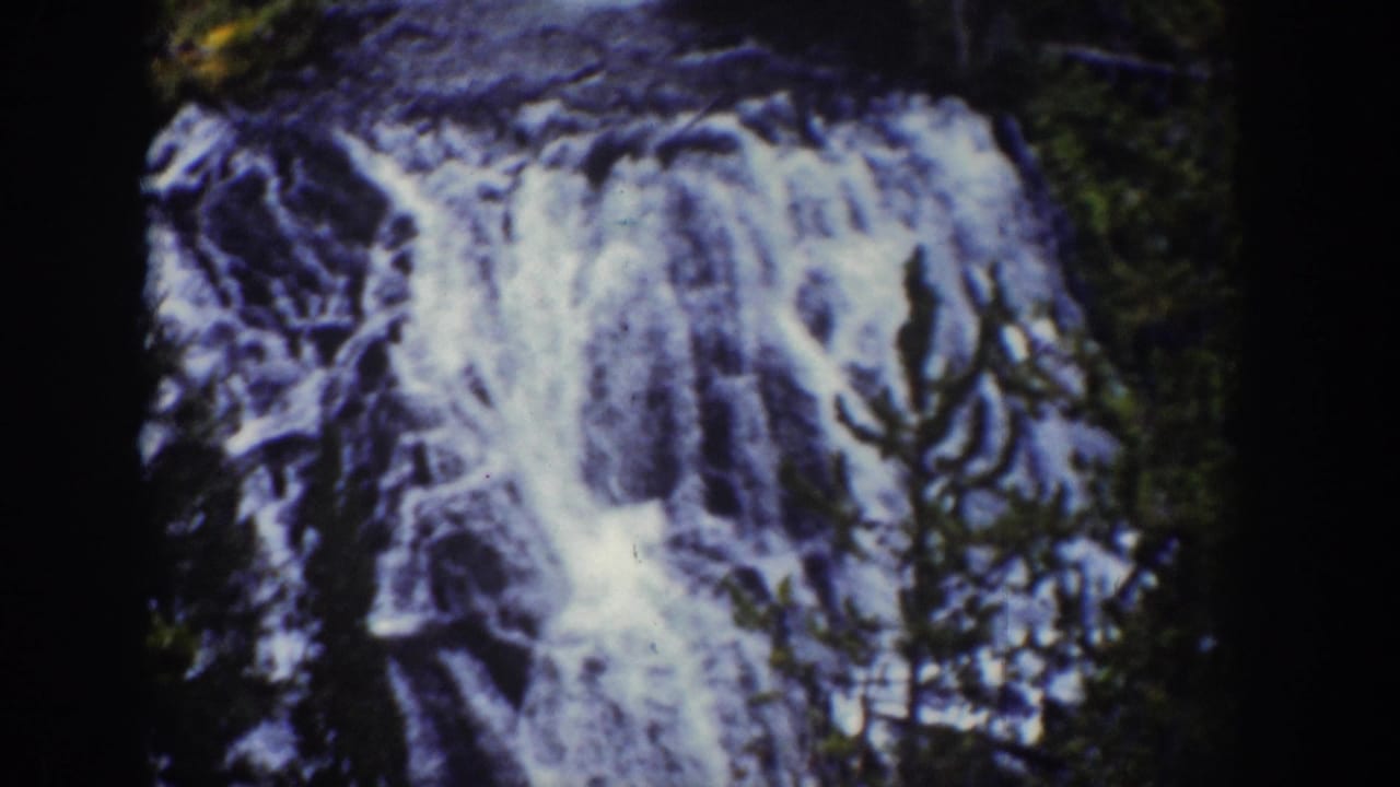 Close view of a bright waterfall descending across dark rock.