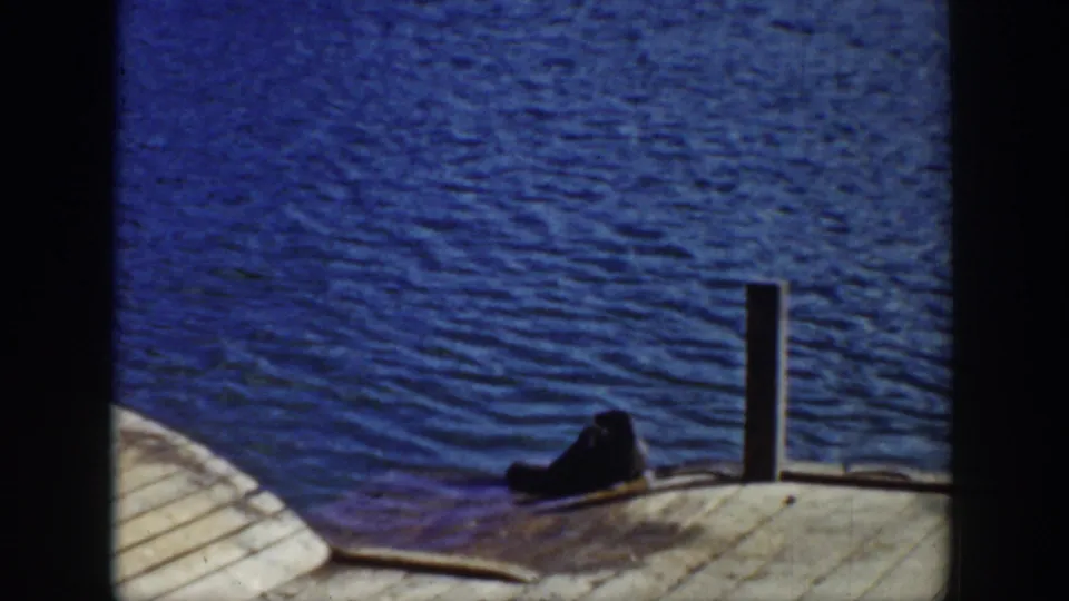 A late frame shows dock planks, a vertical post, and a dark object near the waterline in the Wyoming lake scene.