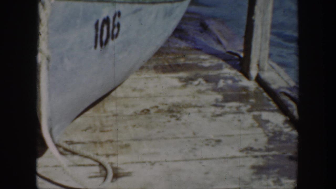 1939 Wyoming 8mm frame of the numbered boat and dock area after the animal has moved out of view.