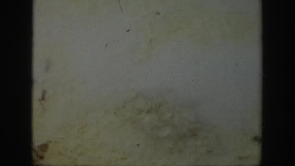 Faded 8mm frame in the 1939 Wyoming clip, showing film texture, dust, and edge shadows rather than a clear landscape view.