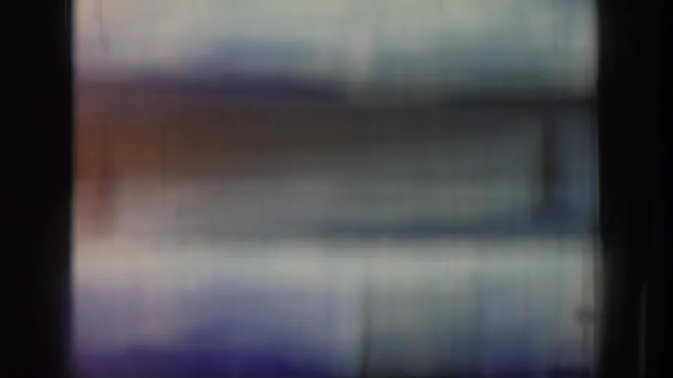 Blurred 8mm contact-sheet frame from the clip opening, with dark frame edges and no clear subjects visible.