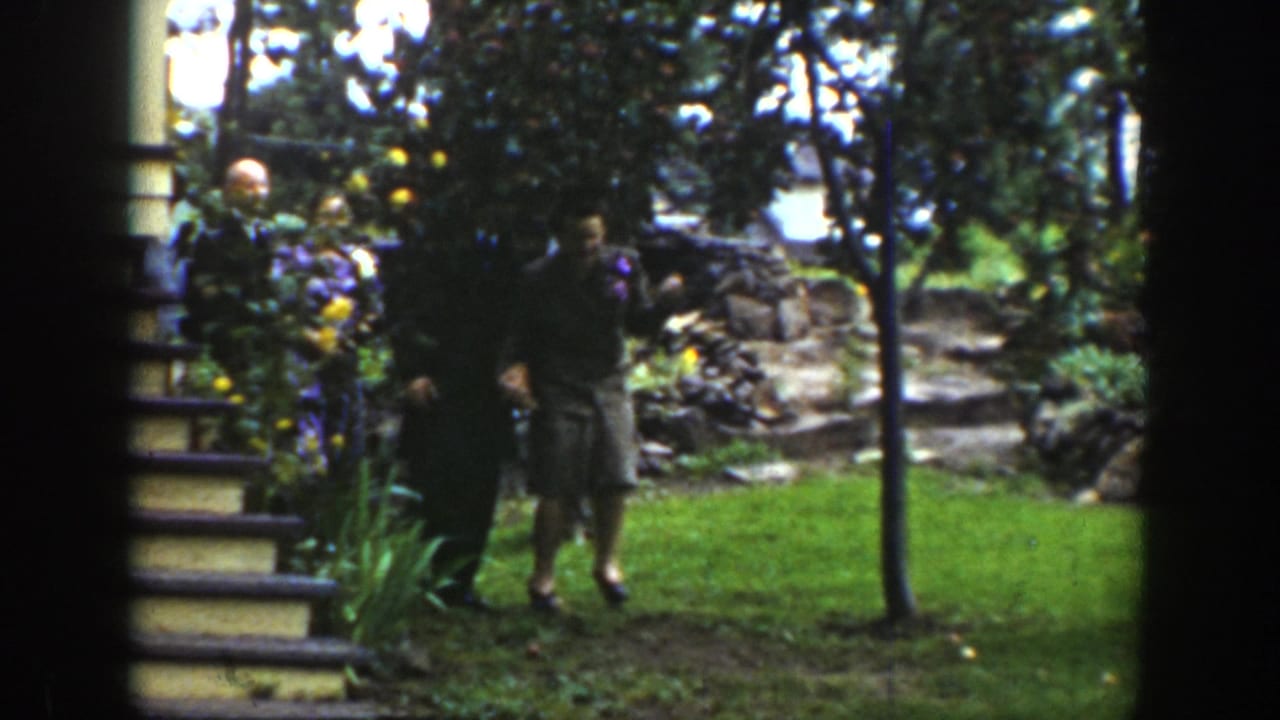 The couple appears in a leafy Wyoming garden with stone steps and flowers visible behind them.