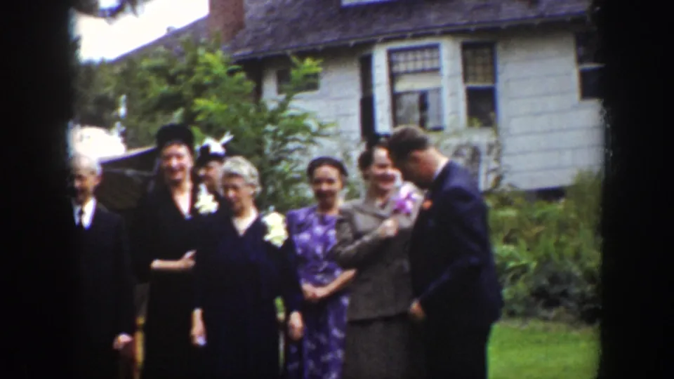 Several adults in formal clothing, including a woman in a patterned dress, pose in a garden in Wyoming archival footage from 1939.