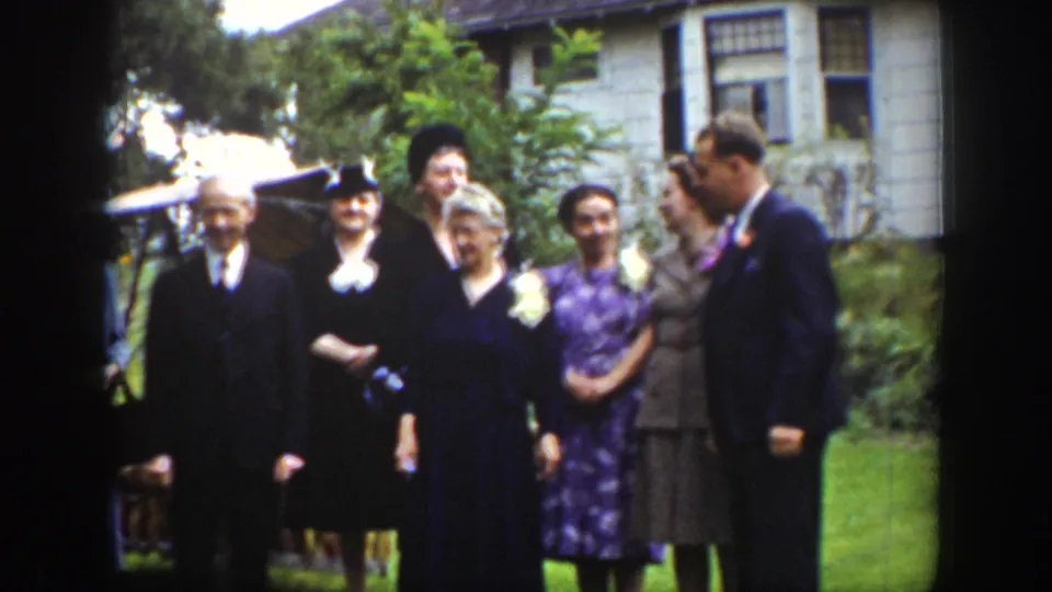 Adults in formal attire stand on a Wyoming lawn as the posed group moment loosens near the end of the clip.