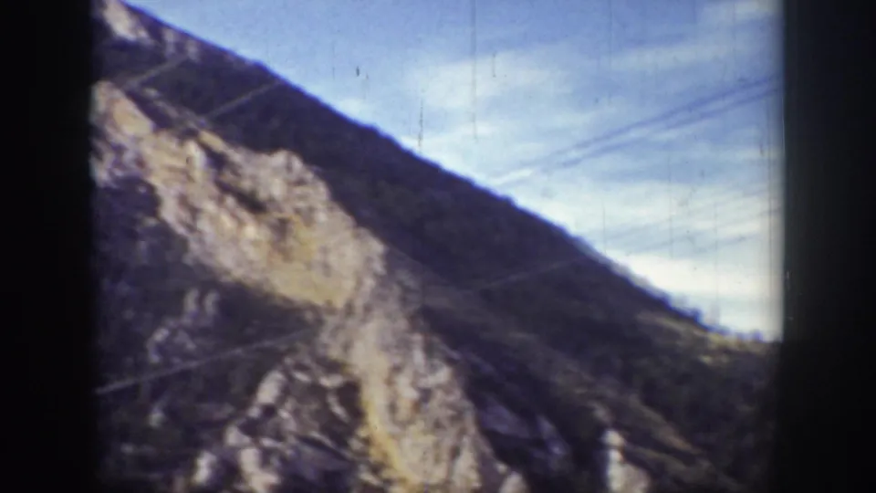 1939 Wyoming 8mm frame showing a rocky slope, open sky, and faint utility wires during the camera pan.