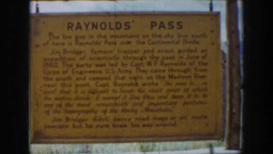 Final 1939 Wyoming 8mm frame holding on the weathered Reynolds' Pass sign and its readable heading.