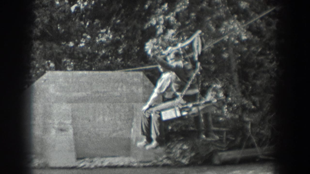 Man rides a cable seat while another person stands near the right side.