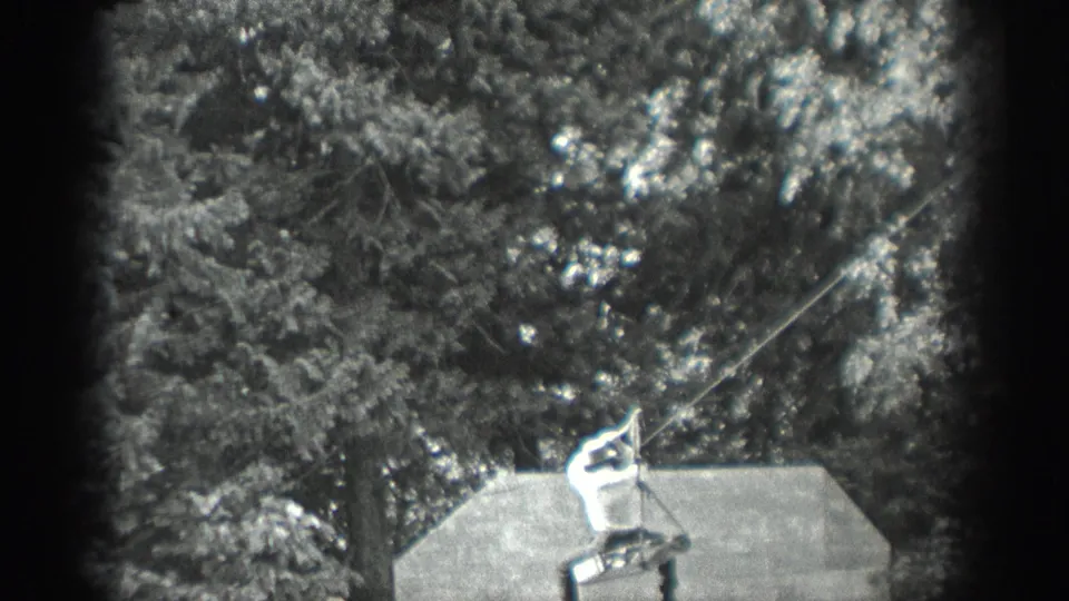 A 1940 Washington home-movie frame shows the man holding the angled line with both hands near the platform and wooded backdrop.