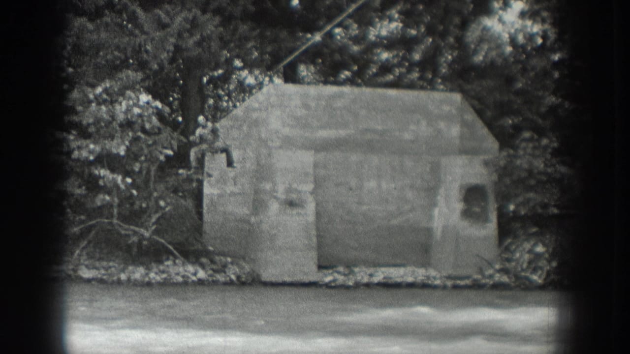 Riverbank concrete structure and trees with a cable stretched overhead.