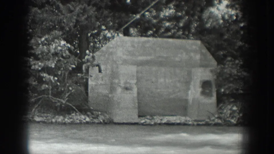 The wooded Washington riverbank and concrete structure remain in view, with the suspended crossing cable visible above the water.