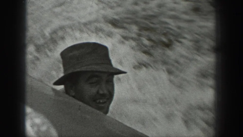 In Washington 1940 home-movie footage, a man in a brimmed hat smiles while partly obscured during a boat ride.