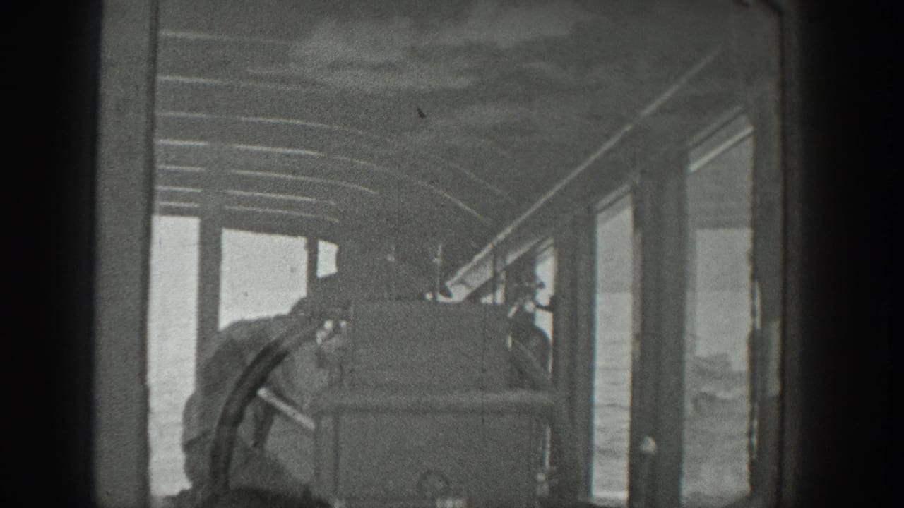 View into a boat cabin with windows, framing, and passengers near the front.