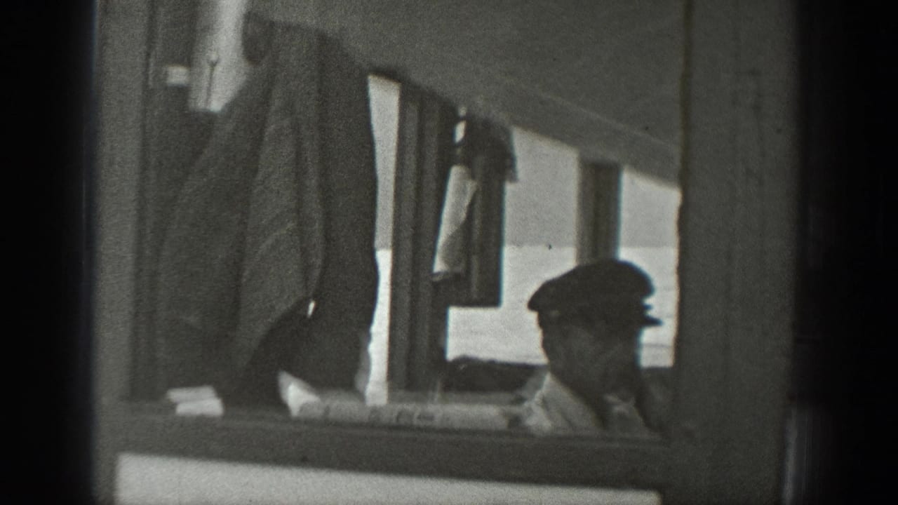 1940 Washington 8mm frame showing a seated man in a cap partly framed by the side of a small boat.