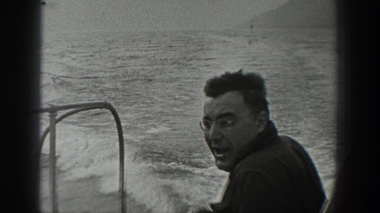 In 1940 Washington home-movie footage, an adult man in glasses smiles back from a motorboat as wake trails behind him.