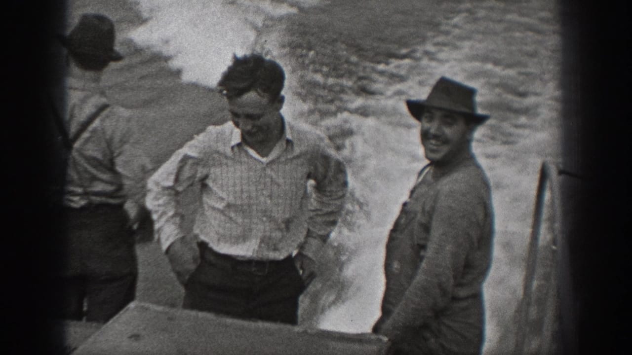 1940 Washington 8mm frame with adult men on a boat, including one smiling toward the camera beside the wake.