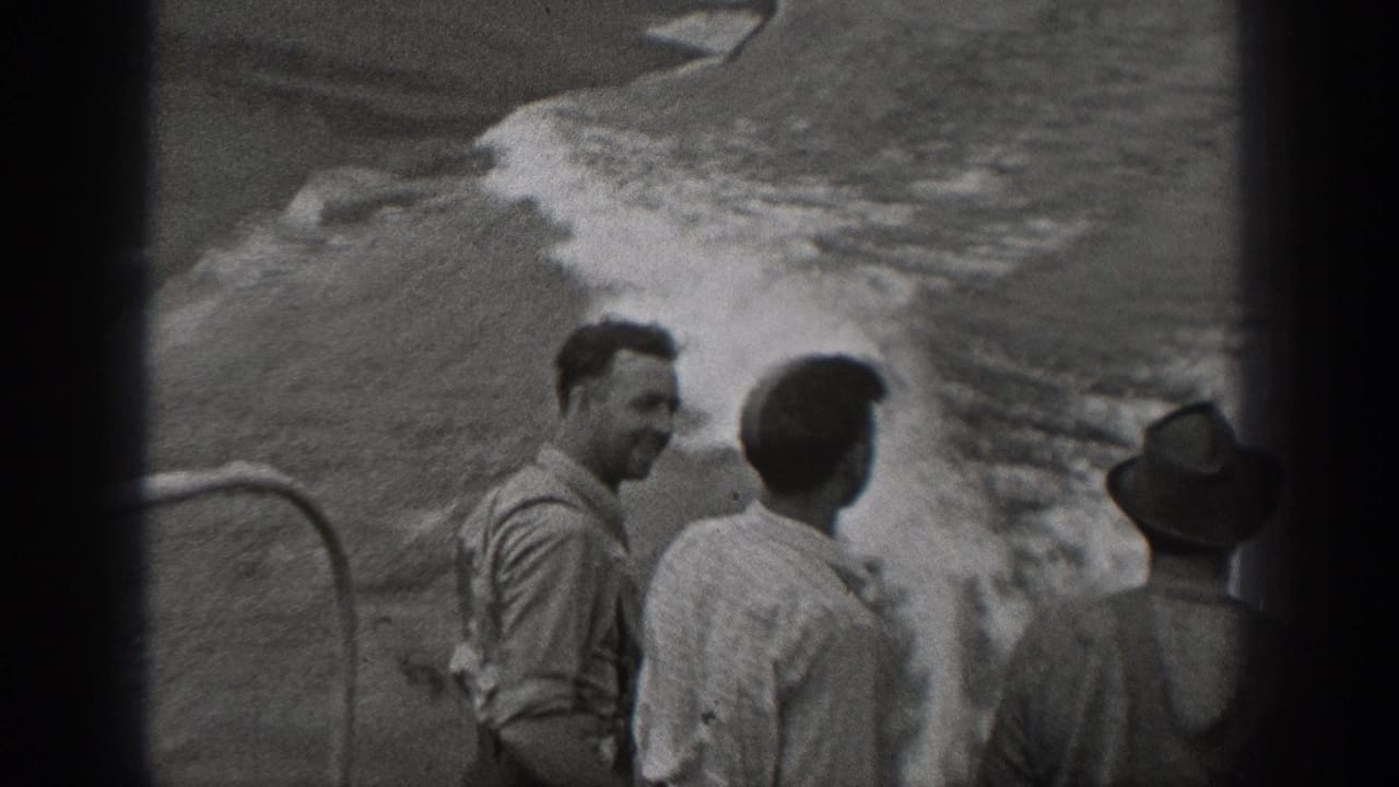 Adult men on a large ship in Washington-area 1940 home-movie footage watch waves breaking alongside the deck.