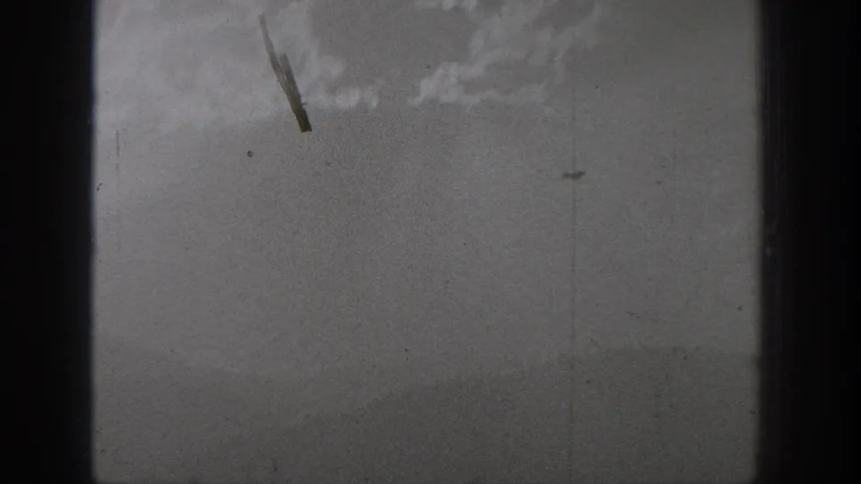The final frame is largely obscured or overexposed, with faint monochrome texture and small film debris visible near the top.