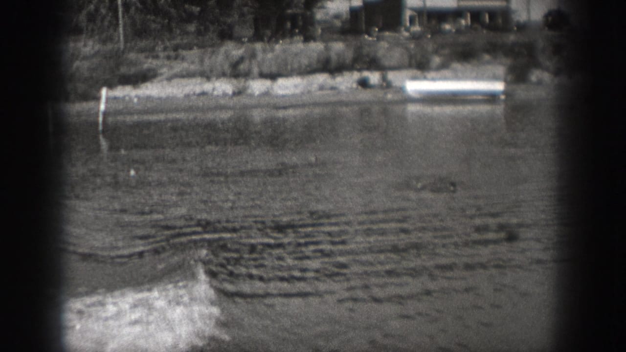 Small motorboat begins to enter the river view, leaving ripples behind.