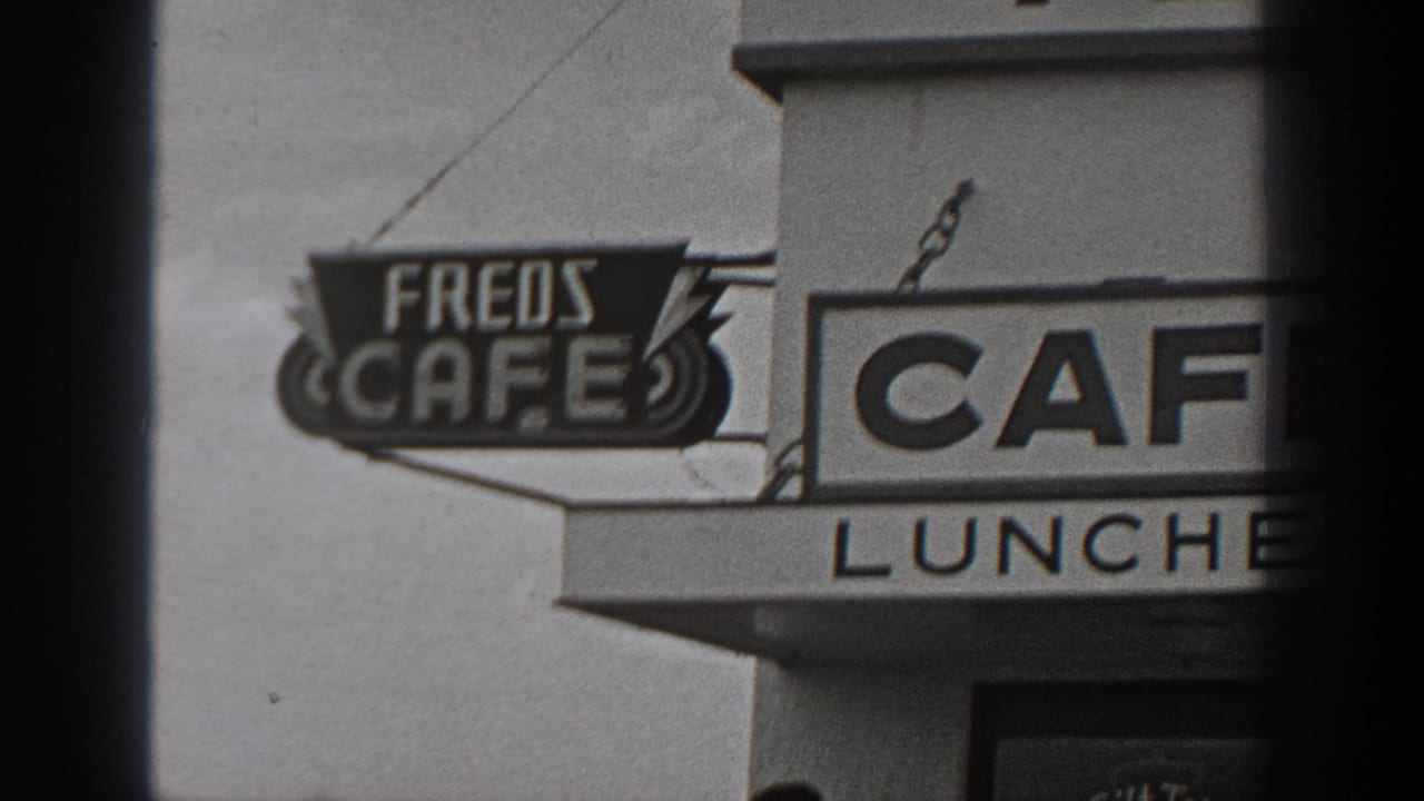 1940 Washington home-movie frame showing Fred's Cafe signage, LUNCHES lettering, and a roadside cafe exterior.