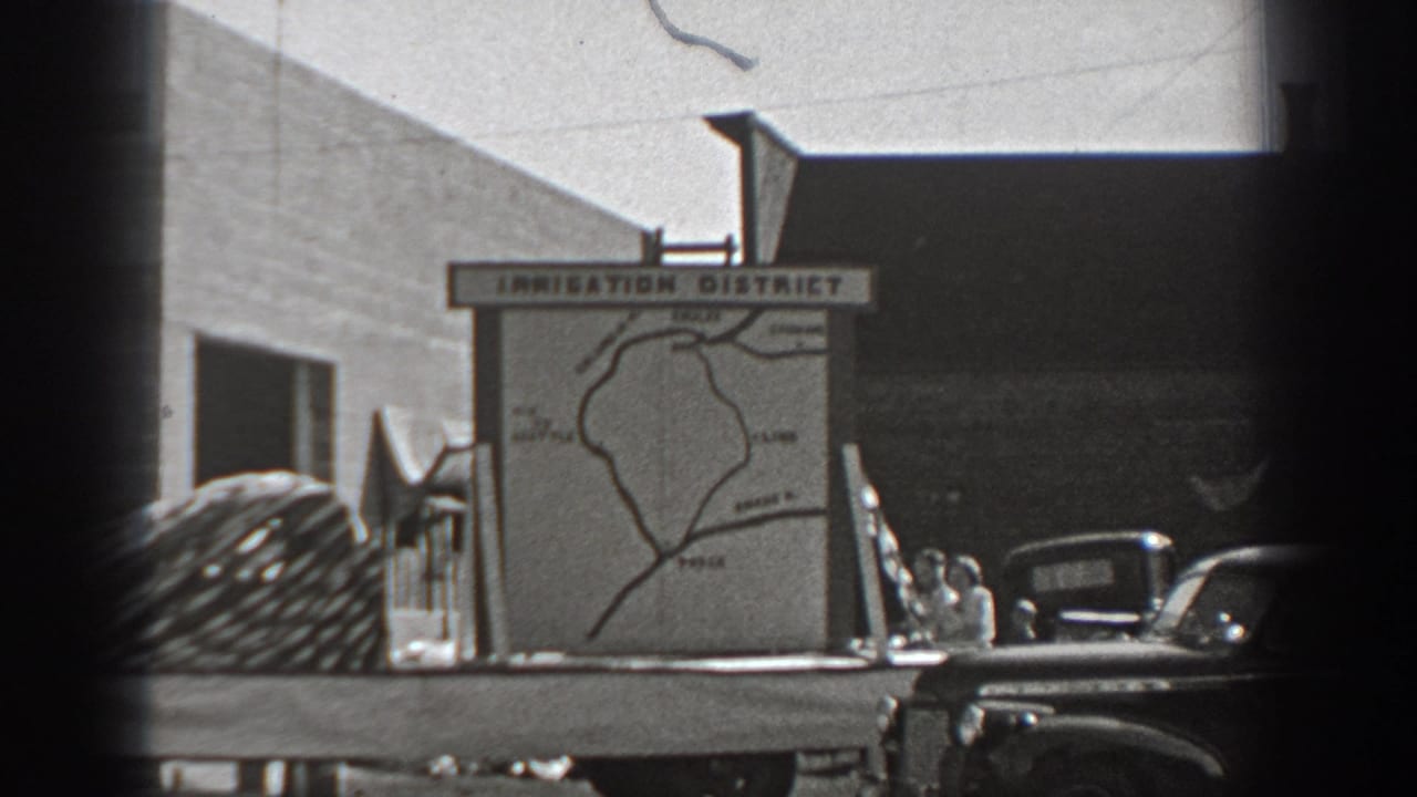 Irrigation district sign and map with parked trucks visible in the background.