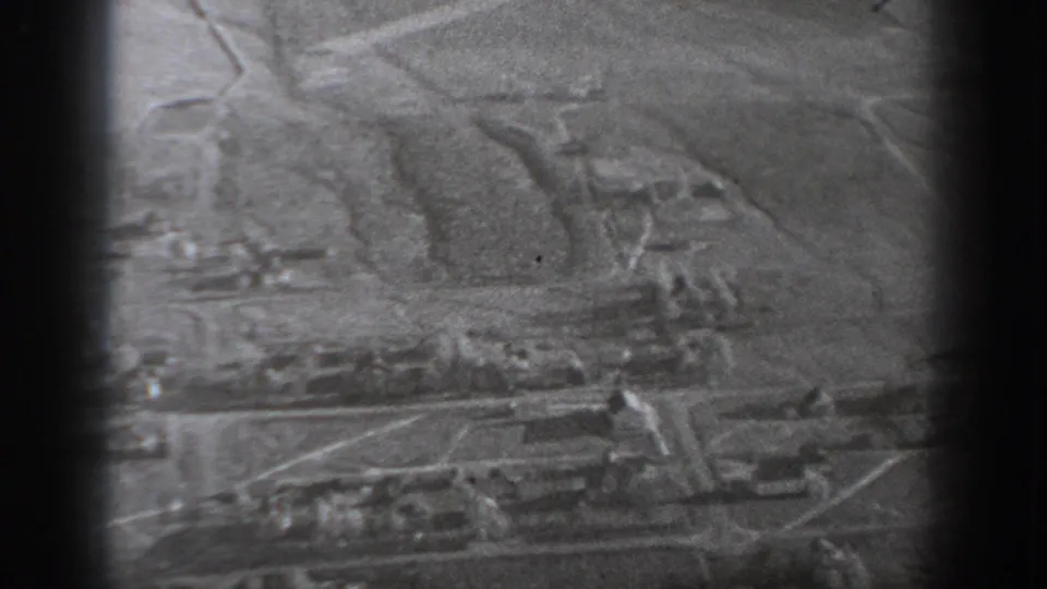 A close, soft-focus black-and-white view shows a textured surface with irregular lines, likely a closer look at a map or ground detail from the same scene.