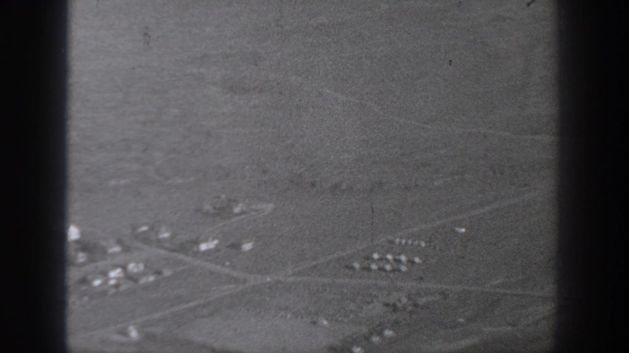 1940 Washington aerial frame showing open rural land, small structures, pale road lines, and dark film or window borders.