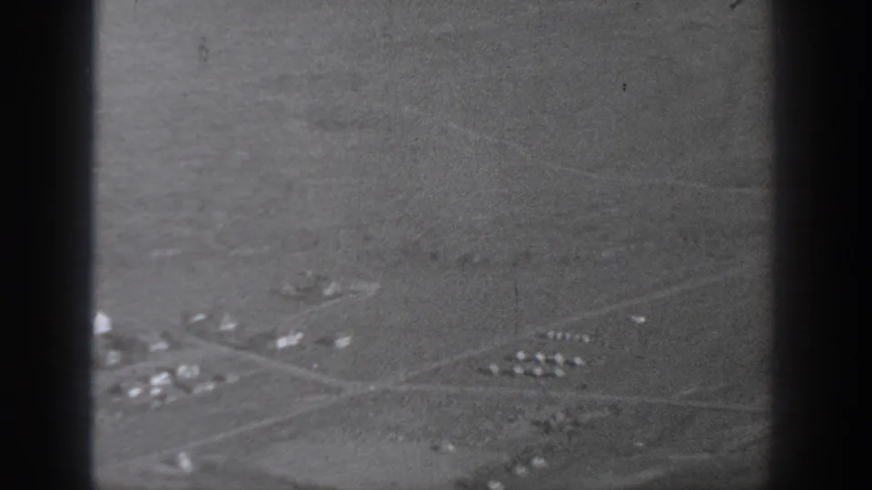 1940 Washington aerial frame showing open rural land, small structures, pale road lines, and dark film or window borders.