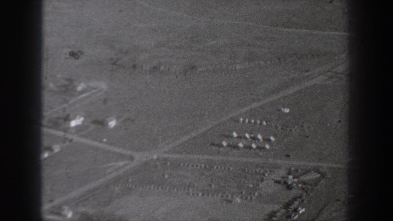 1940 Washington aerial view with intersecting roads, open fields, and small building groups in soft black-and-white film.
