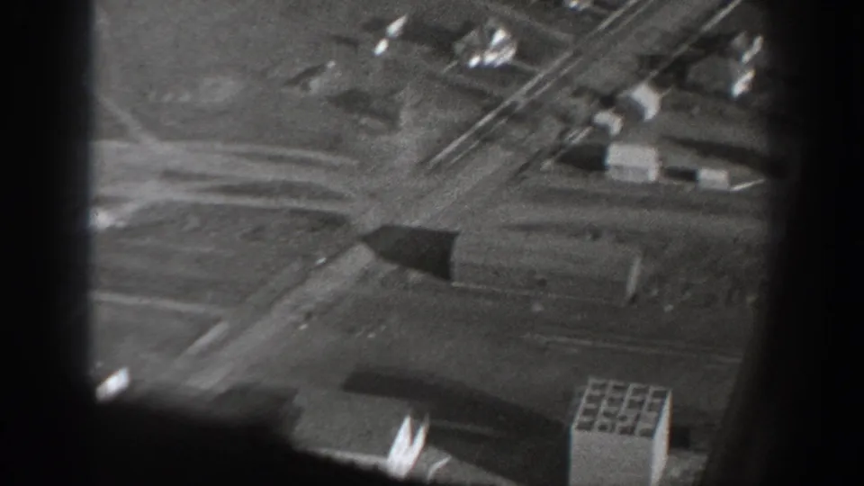 1940 Washington aerial frame showing a closer view of rural structures, roads, field divisions, and dark film-frame borders.