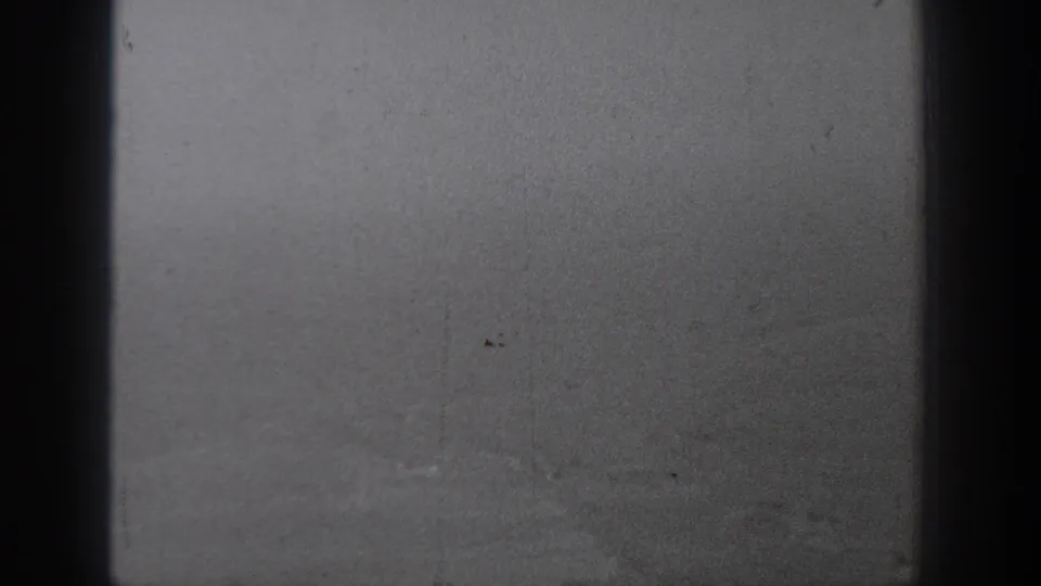 1940s 8mm view from an aircraft window over a hazy rural Washington landscape, partly obscured by dark window framing.