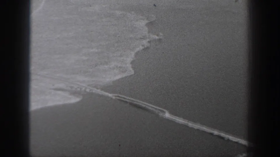 Obstructed 1940 Washington home-movie view with dark framing and a curved water or land edge in soft focus.