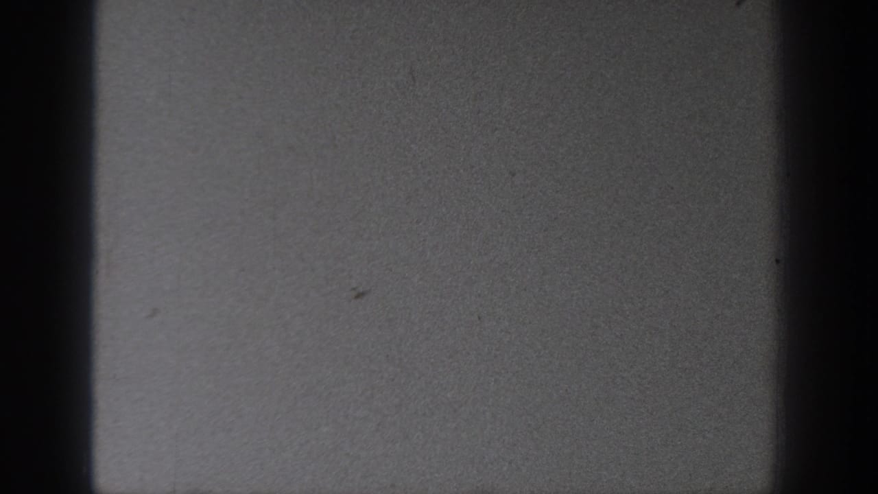 Washington 1940 home-movie frame with dark gate edges and a largely blank, softly exposed field of sky or film leader.