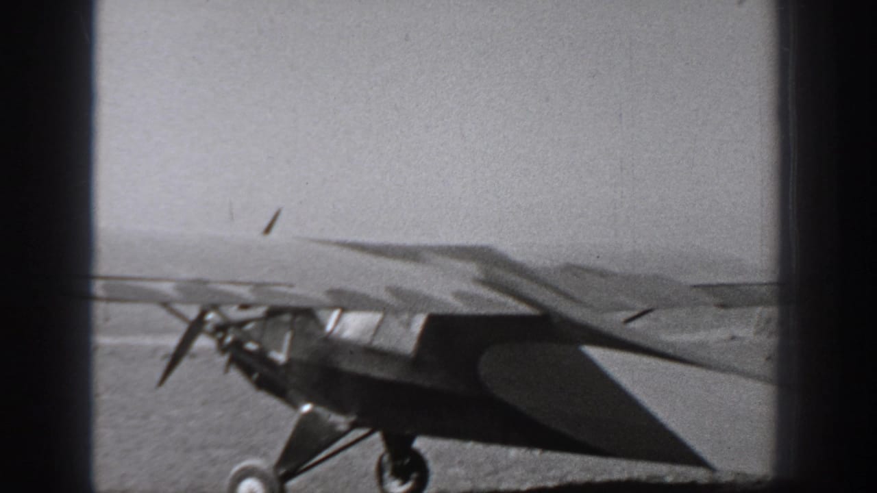 Small propeller aircraft on an open Washington airfield in 1940-era black-and-white home-movie footage.