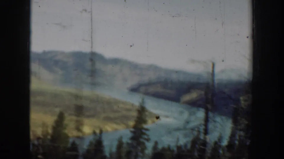 1940s Washington 8mm view of a winding river between hills, with evergreens and a dark car-window border.