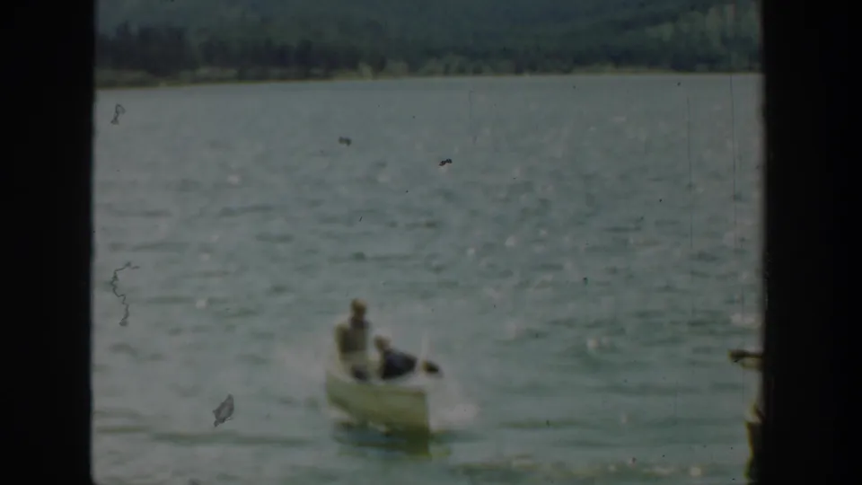 Two men appear in a small white rowboat on a Washington lake in 1940-era 8mm home-movie footage.