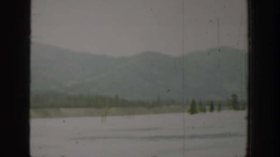 Soft 8mm view of Washington mountains and a wide body of water, partially blocked by a dark window divider.