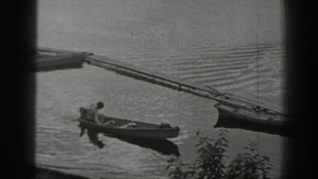 The man remains seated in the small boat as it drifts near a dock and another boat on a calm Washington lake.