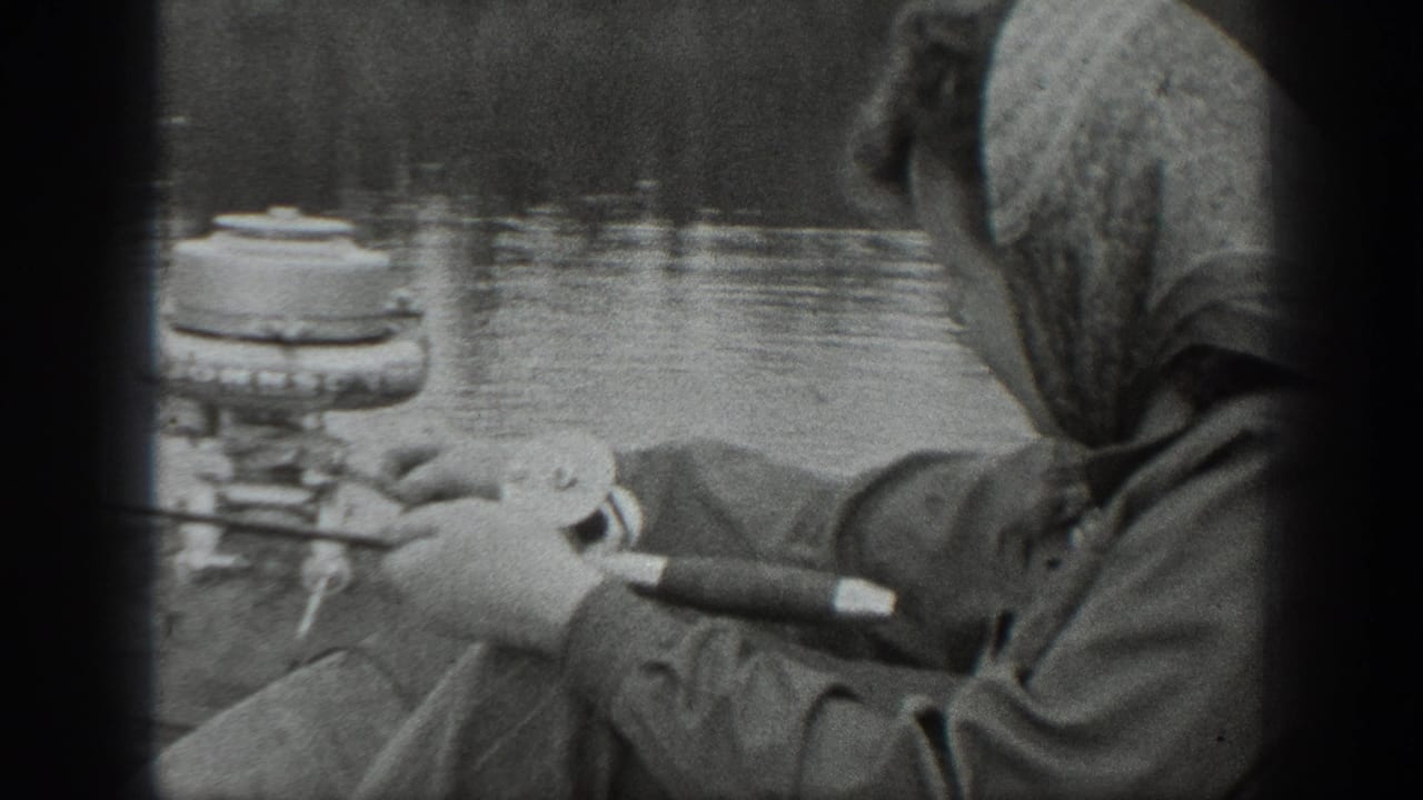 1940 Washington 8mm frame showing a woman in a headscarf and coat fishing from a small boat on a calm lake.
