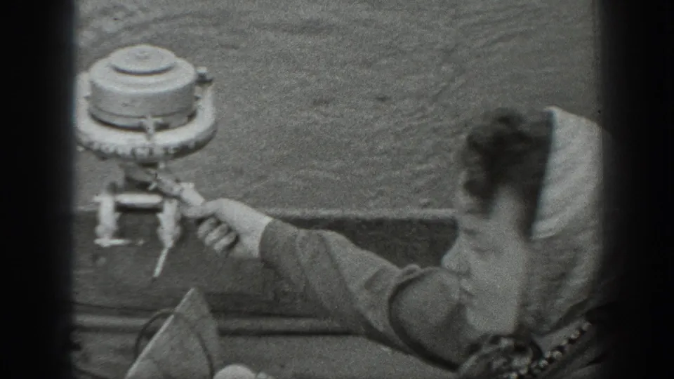 1940 Washington home-movie close-up of fishing gear and a seated person in a small boat on the lake.