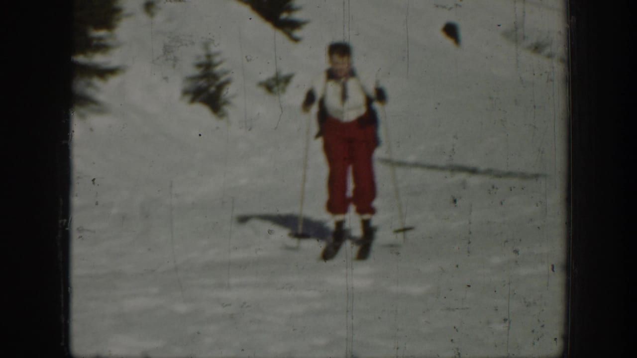 A skier in red pants and a light top stands on a snowy Washington slope in 1940 archival 8mm footage.