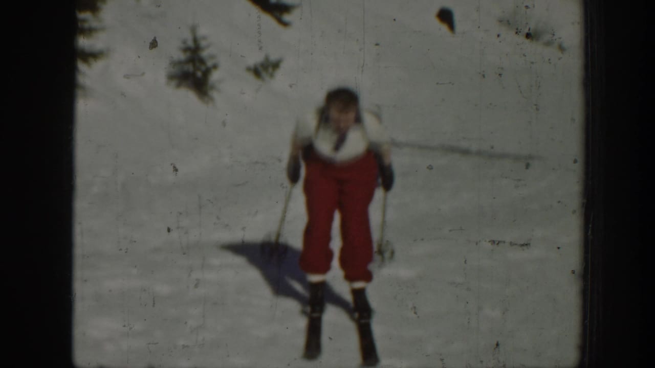 The skier approaches the camera on a snow-covered Washington slope, framed by soft 8mm home-movie focus.