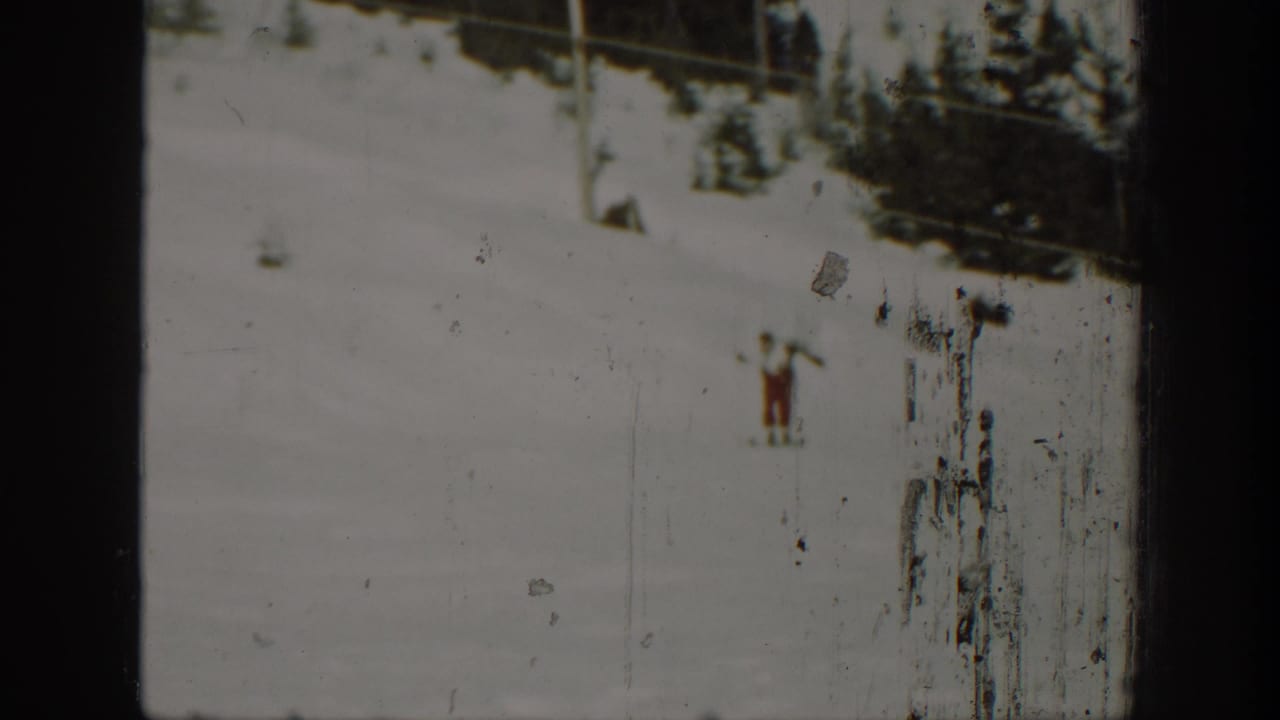 1940 Washington home-movie frame with a lone skier on snow, seen through a worn 8mm film frame.